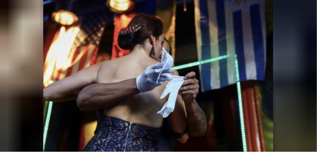 Makrina Anastasiadou'nun partneri 'El Morocho', neredeyse boş bir restoranda halka dans etmeden önce eldiven giyiyor. Fotoğraf: REUTERS / Matias Baglietto